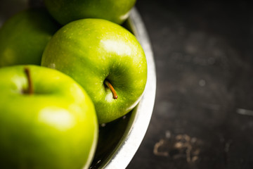 Close-up green apples on the rustic wooden background. Selective focus. Shallow depth of field.