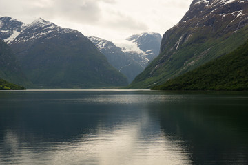 View towards the misty peaks of Jakta and Slogen and the waters of Horjundfjord from the region of Saebo in Norway
