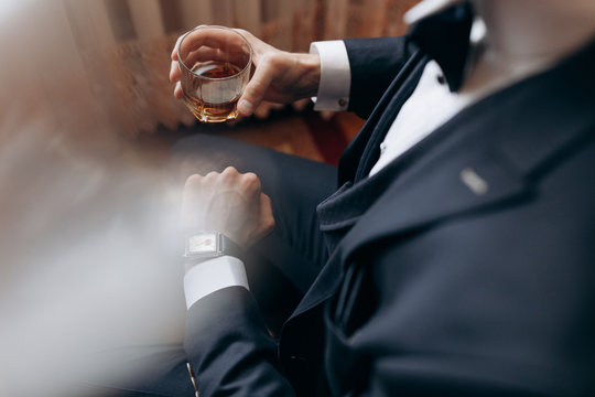 Successful business meeting. Deal. Wedding Bride groom on husband with glass. Man drink whiskey. Formal male fashion. Chears.