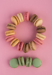 Colorful Macaron, French confectioner cake in different flavors on a pink background.