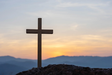 Silhouettes of crucifix symbol with bright sunbeam on the colorful sky background