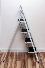 ladder with four steps standing against the wall