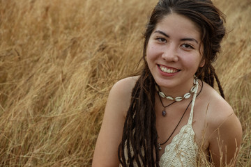 Young Woman Sitting On Dry Grass