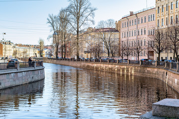 buildings on the embankment of red brick reflected in the water