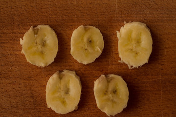 Naklejka na ściany i meble five slices of yellow banana on a wooden board like olympic rings