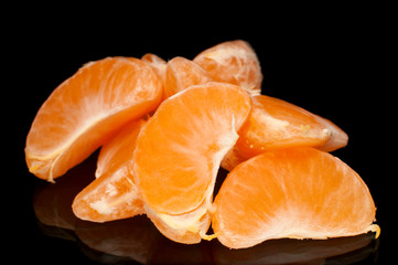 Ripe tangerines on a black background with reflection