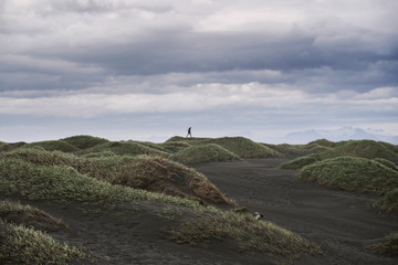 Lone person walking in dunes far away