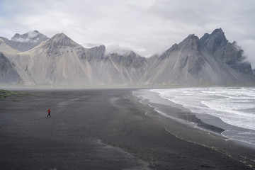 Stokksnes, woman running towards the waves