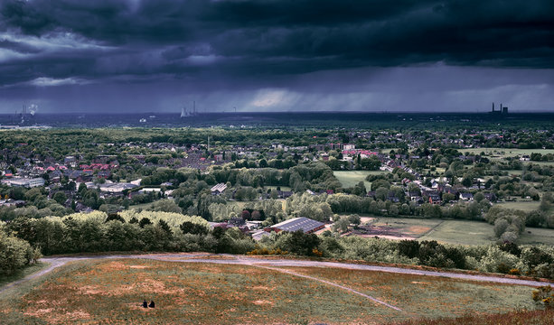 Ausblick auf starken Regen und dunkle Wolken &uuml;ber dem westlichen Ruhrgebiet in Richtung Duisburg von der Halde Haniel aus gesehen. 