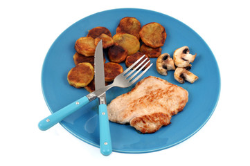 Veal cutlet with fried potatoes served in a plate on white background