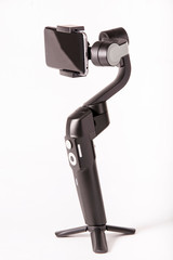 Photographer with video gimbal, smartphone stabilizer and tripod for balanced shots in studio on white background.