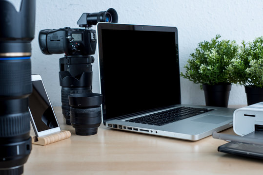 Photographer's Desk With Lenses, Laptop, Phone, Photo Printer On A Neutral Background.