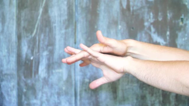 Une des 5 mani&egrave;re pour se laver les mains du coronavirus par d&eacute;sinfection  en pulv&eacute;risant du gel hydroalcoolique, sur un fond en bois bleu.
