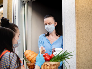 Teen girl volunteer delivers food to the house during the quarantine.