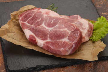 Raw pork steak over wooden board