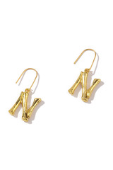 Obraz na płótnie Canvas Subject shot of two golden hook earrings with pendants in the shape of letters N stylized as bamboo sticks. The fashion earrings are isolated on the white background.