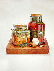 Pickles in a jar of red pepper and olive carrots garlic cucumber and dill