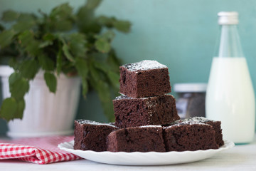 Pieces of chocolate cake on a white plate and a red and white checkered napkin. Dessert, Milk and Chocolate Drops