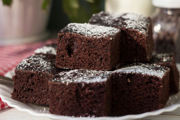 Pieces of chocolate cake on a white plate and a red and white checkered napkin. Dessert, Milk and Chocolate Drops