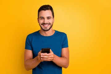 Close-up portrait of his he nice attractive glad cheerful cheery guy using cell comment feedback repost smm service isolated over bright vivid shine vibrant yellow color background