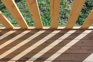 wooden railings cast a shadow on the boardwalk floor