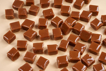 Pieces of caramel on beige background