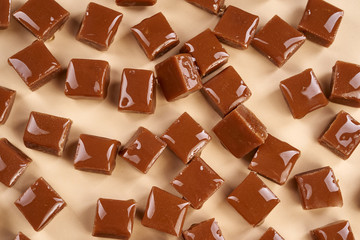 Closeup pieces of caramel on beige background