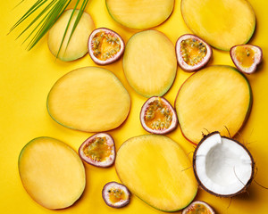 Flat lay of mango slices on yellow paper background