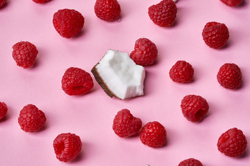 Raspberries with coconut piece on pink background