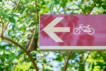 red signboard indicates bicycle track. In the background green trees