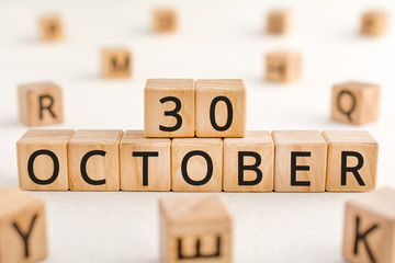 October 30 - from wooden blocks with letters, important date concept, white background random letters around