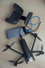 Powerbank-Ladegerät mit Drohne und Akku, von oben auf einem Tisch fotografiert.