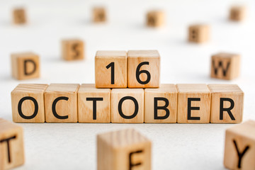 October 16 - from wooden blocks with letters, important date concept, white background random letters around