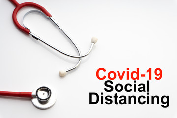 COVID-19 SOCIAL DISTANCING text with stethoscope on white background. Covid or Coronavirus Concept
