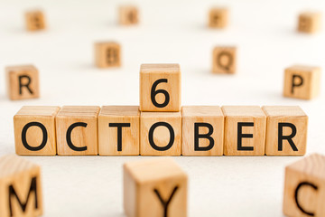 October 6 - from wooden blocks with letters, important date concept, white background random letters around