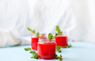 Glasses of homemade cold juice with mint with fresh berries on a light background. Selective focus.