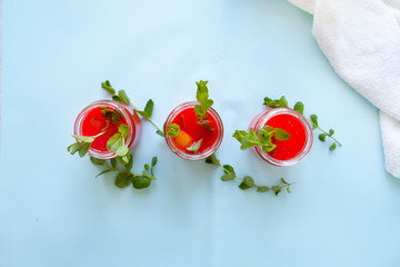 Glasses of homemade cold juice with mint with fresh berries on a light background. Selective focus.