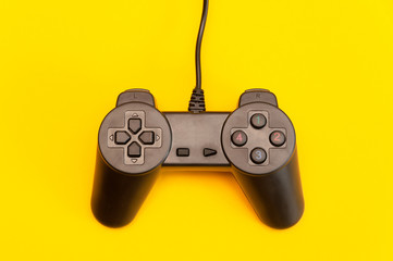 black plastic joystick on a yellow background, top view