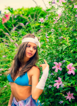 Fototapeta Model looking Girl standing in a swimsuit on the background of green grass and forest. Copy space