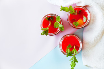 Glasses of homemade cold juice with mint with fresh berries on a light background. Selective focus.