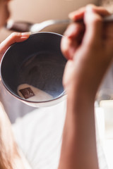 woman lying in bed eating a bowl of muesli with a book and glasses. Culture and education concept