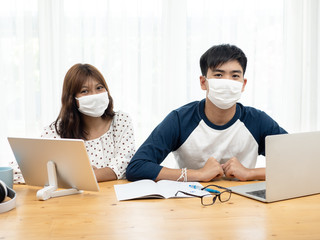 Asian teenager using  laptop and tablet for online schooling from home together, quarantine concept.