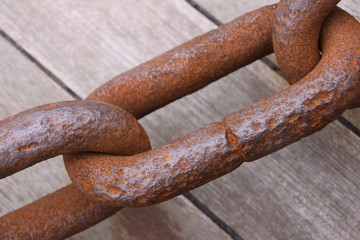 Old weathered industrial link of steel chain. From very close.