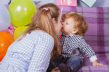 One year old baby with his mom. Boy celebrates a birthday. Portrait of mom with a baby