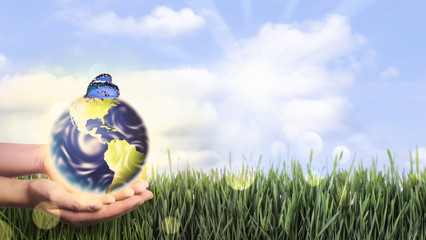 Woman holding Earth with butterfly outdoors, closeup