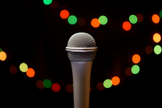Microphone on stage against the background of multi-colored lights