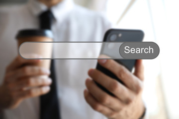 Search bar of internet browser and man using smartphone indoors, closeup