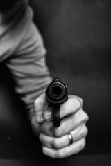 Male hand with gun isolated on black background. Man with a gun ready to shoot, focus on the weapon.