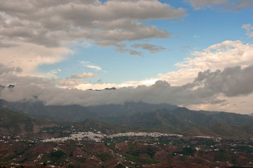 Storm clouds surrounding The Moorish village of Frigiliana nestling in the mountains, Costa del Sol, Andalucia, Spain