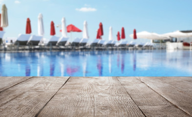 Wooden deck near swimming pool outdoors on sunny day. Space for text